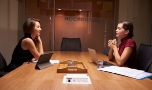 two-businesswomen-working-late-sitting-opposite-each-other-picture-id639468142 (1)