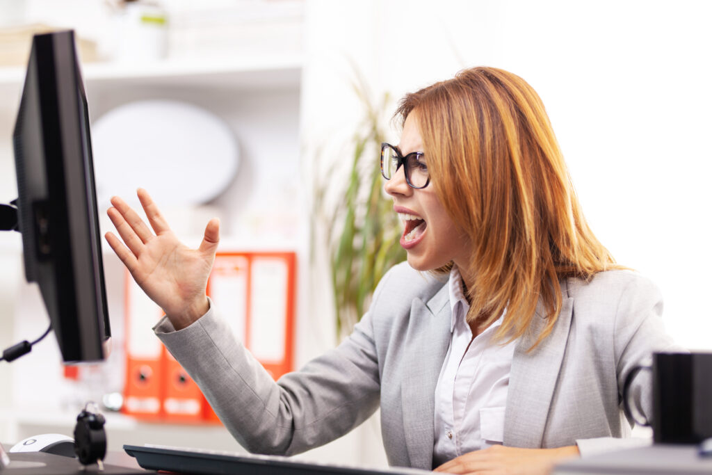 angry businesswoman in front of a computer in an office