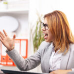 angry businesswoman in front of a computer in an office