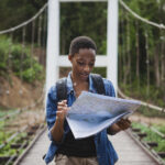 African American woman looking at a map travel and explore concept