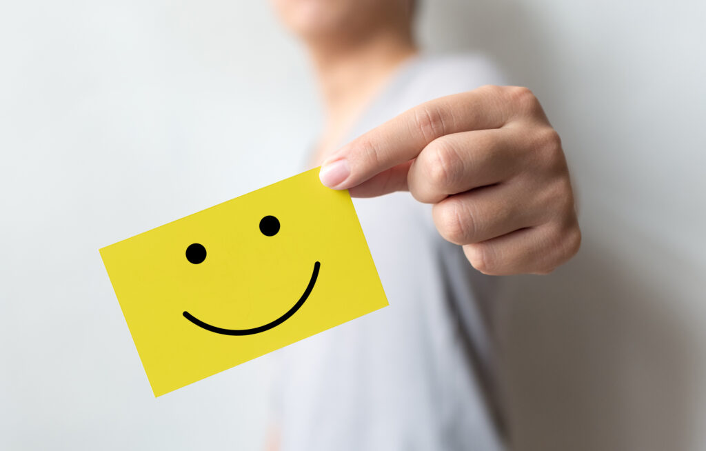 Customer service experience and business satisfaction survey. Man holding yellow card with smiley face