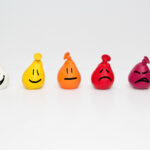 different doodle faces on coloured balloons