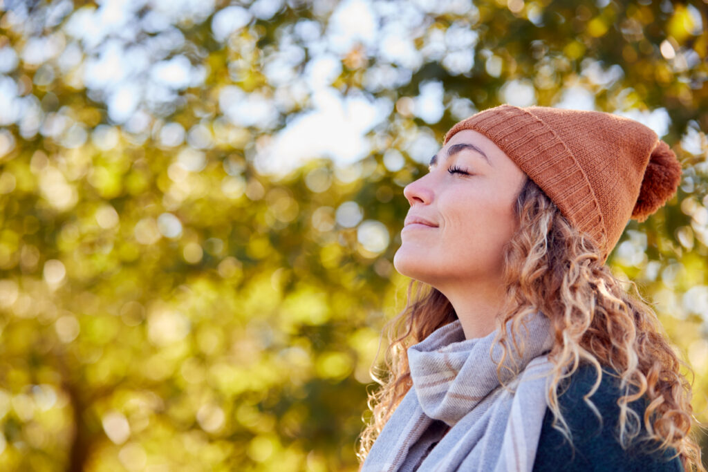 Calm Young Woman Wearing Hat And Scarf Relaxing And Breathing In Deeply In Autumn Park